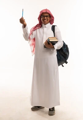 طالب سعودي بالثوب التقليدي يحمل قلماً وكتباً