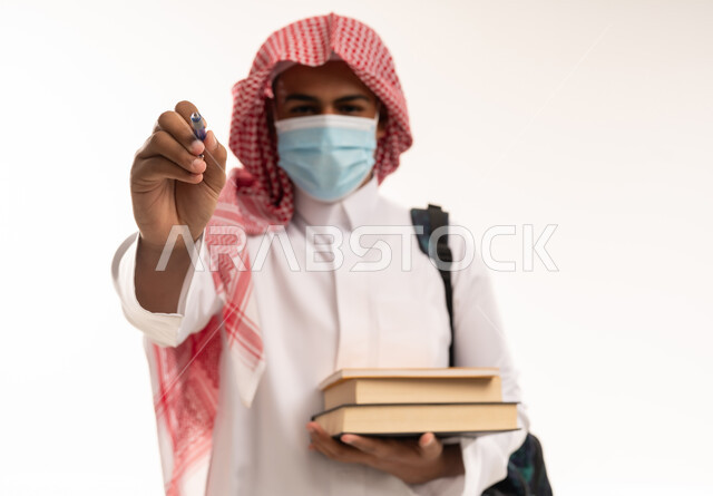 طالب سعودي في استوديو يرتدي الكمامة الواقية