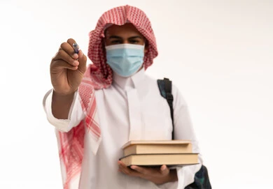 طالب سعودي في استوديو يرتدي الكمامة الواقية