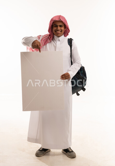 طالب سعودي يحمل لوحة بيضاء فارغة بخلفية بيضاء