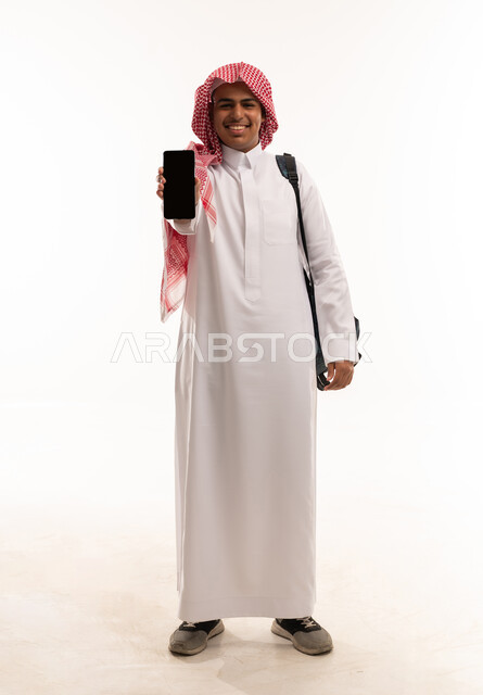 رجل سعودي بالثوب يحمل هاتف ذكي بخلفية بيضاء
