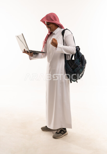 طالب سعودي يحمل لاب توب ويحتفل بالنجاح
