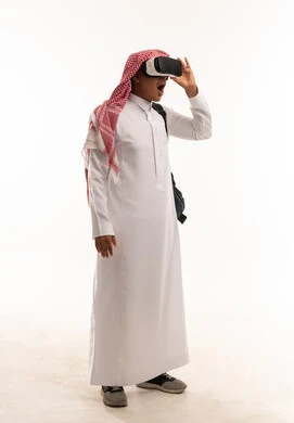 رجل سعودي يستخدم نظارة الواقع الافتراضي بتعبير مندهش