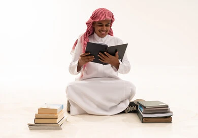 طالب سعودي بالزي التقليدي يقرأ الكتب