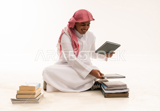 رجل سعودي بالزي التقليدي ينظم الكتب التعليمية