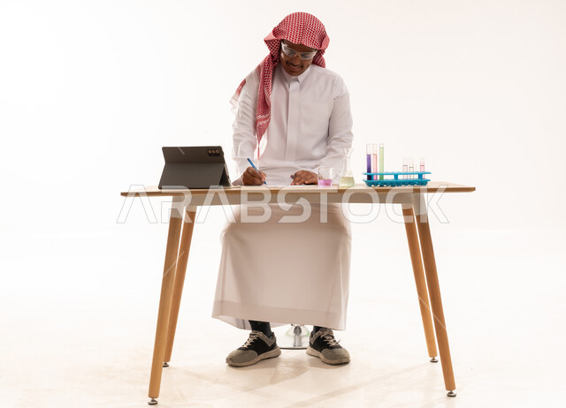 عالم سعودي بالزي التقليدي يستخدم أدوات المختبر