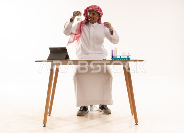 عالم سعودي بالثوب التقليدي يجري تجربة كيميائية