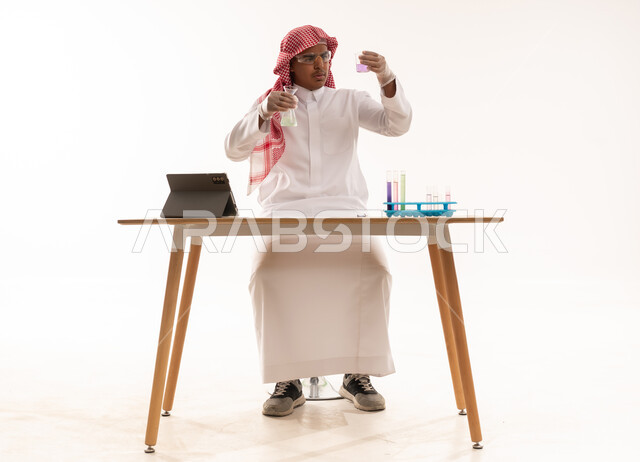 عالم سعودي يجري تجربة كيميائية باستخدام أدوات مخبرية