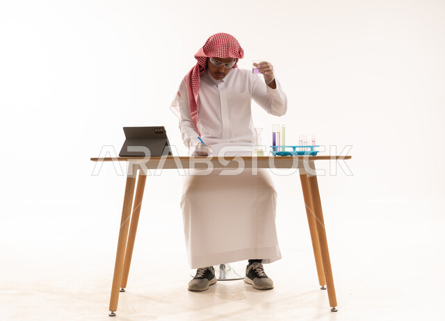 عالم سعودي يجري تجربة كيميائية على خلفية بيضاء