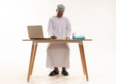عالم عماني مع معدات المختبر على المكتب