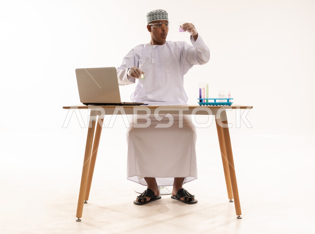عالم عماني مع حاسوب محمول وعينات كيميائية