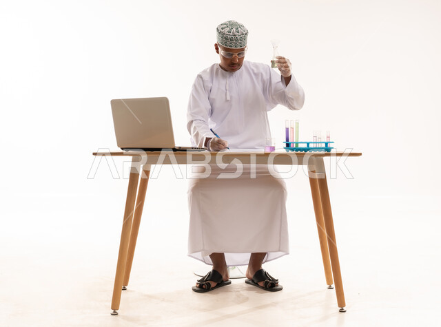عالم عماني بالزي التقليدي يجري أبحاثاً مخبرية