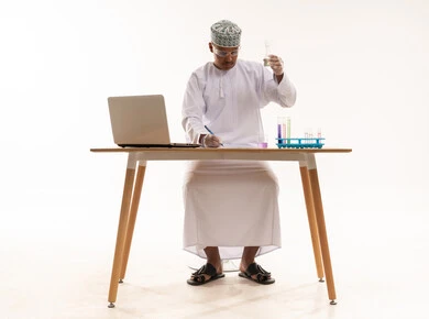 عالم عماني بالزي التقليدي يجري أبحاثاً مخبرية