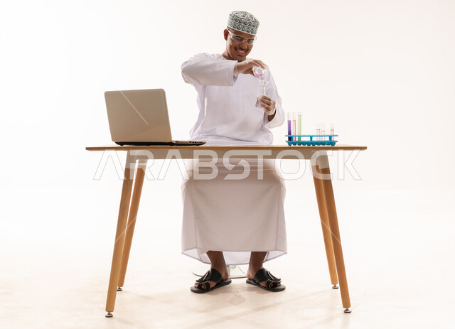 عالم عُماني يعمل في مختبر مع جهاز محمول