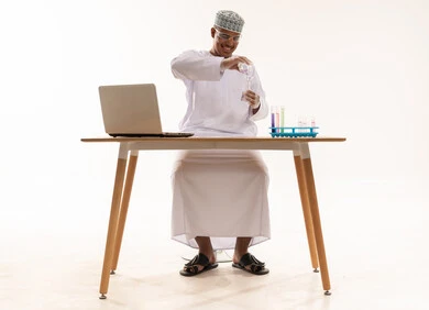 عالم عُماني يعمل في مختبر مع جهاز محمول عالم عُماني يعمل في مختبر مع جهاز محمول
