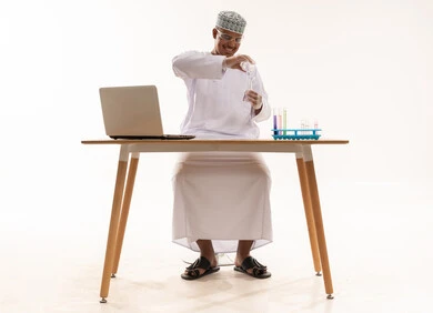 عالم عُماني يجري تجربة كيميائية في مختبر