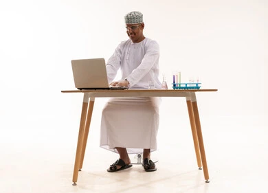 Omani Scientist with Laptop and Laboratory Equipment