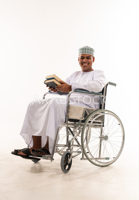 Omani Man in Wheelchair Holding Books Studio