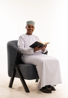 Omani Man in Traditional Dress Reading Book