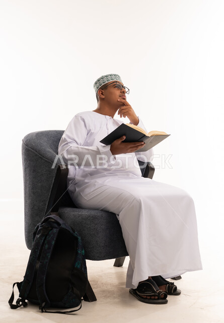 Omani Student Reading Book in Traditional Dress