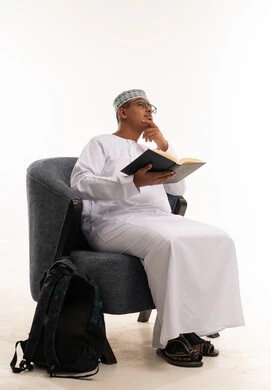 Omani Student Reading Book in Traditional Dress