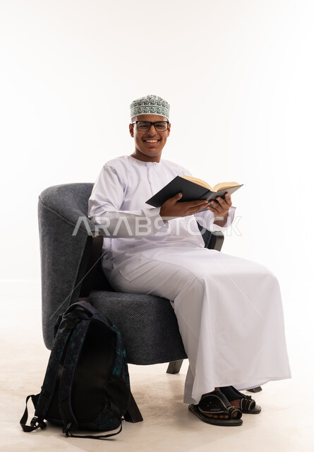 Omani Student in Traditional Dress Reading a Book