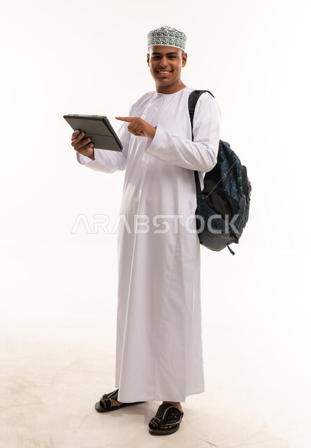 رجل عماني مع جهاز لوحي وحقيبة ظهر