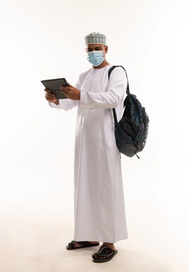 رجل عماني بالزي التقليدي يستخدم جهاز لوحي مع كمامة