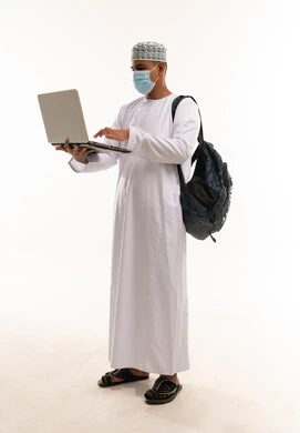 رجل عماني يستخدم المحمول مع كمامة وحقيبة ظهر