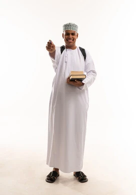 طالب عماني بالزي التقليدي يحمل كتباً وأدوات دراسية