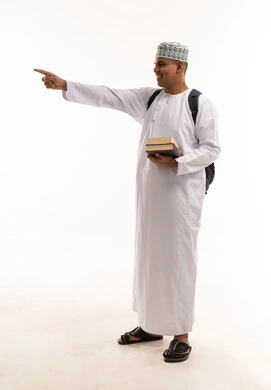 طالب عماني يحمل كتباً ويشير على خلفية بيضاء