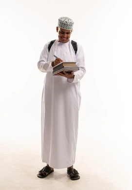 طالب عماني بالزي التقليدي يكتب ويحمل كتب