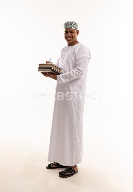 Omani Man in Traditional Dress Holding Books