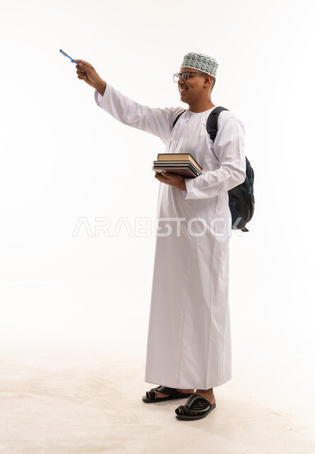 طالب عماني بالزي التقليدي يشير بقلم