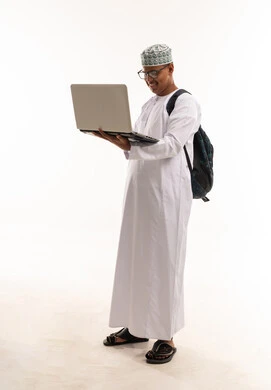 شاب عماني يحمل حاسوب محمول وحقيبة ظهر