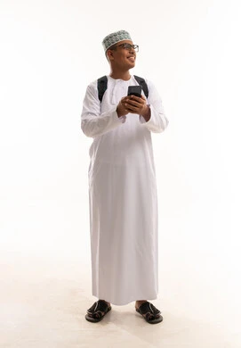 رجل عُماني بالزي التقليدي يحمل هاتف وحقيبة