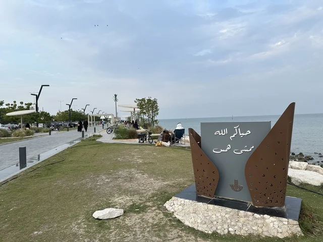 A modern walking experience, the entrance to the Hams walkway in the Eastern Province, Saudi Arabia, an open recreational destination, spaces for walking and relaxation, outdoor seating and benches, diverse restaurants and cafes, a calm family atmosphere.