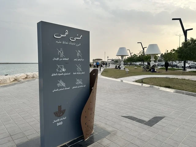 A modern walking experience, the entrance to the Hams walkway in the Eastern Province, Saudi Arabia, an open recreational destination, spaces for walking and relaxation, outdoor seating and benches, diverse restaurants and cafes, a calm family atmosphere.