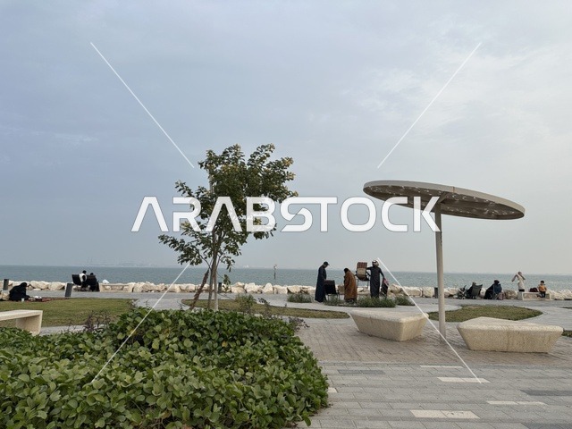 A calm family atmosphere, a modern walking experience, the Hams walkway in the Eastern Province, Saudi Arabia, an open entertainment destination, spaces for walking and relaxation, outdoor seating and benches, diverse restaurants and cafes.