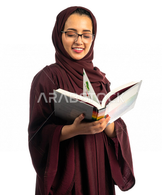 بورتريه طالبة جامعية عربية سعودية خليجية تحمل كتاب التخصص الجامعي , تخصص تصميم داخلي , تصفح وقراءة الكتب الجامعية , التعليم في جامعات المملكة العربية السعودية , خلفية بيضاء .