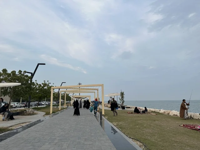 Walking and relaxation areas in Hams Walk in the Eastern Province, Saudi Arabia, a calm family atmosphere, an open recreational destination, a modern walking experience, outdoor seating and benches.