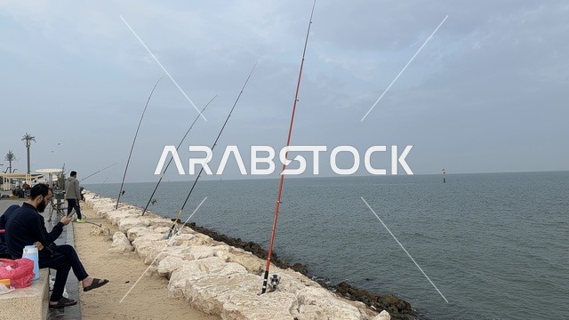 The skill of fishing at the Hams Walkway in the Eastern Province, Saudi Arabia, offers a calm family atmosphere, an open recreational destination, walking and relaxation spaces, a modern strolling experience, and outdoor seating and benches.