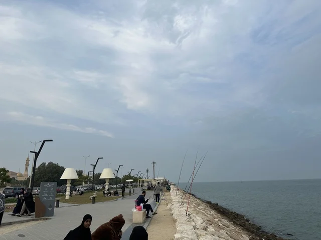 The skill of fishing at the Hams Walkway in the Eastern Province, Saudi Arabia, offers a calm family atmosphere, an open recreational destination, walking and relaxation spaces, a modern strolling experience, and outdoor seating and benches.