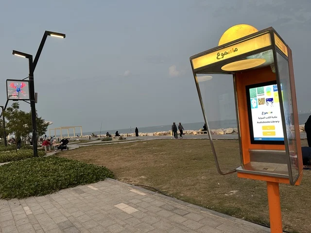 The audio library cabins "Masmoo" in the Hams Walkway in the Eastern Province, Saudi Arabia, offer a calm family atmosphere, spaces for walking and relaxation, an open entertainment destination, a modern strolling experience, and outdoor seating and benches.