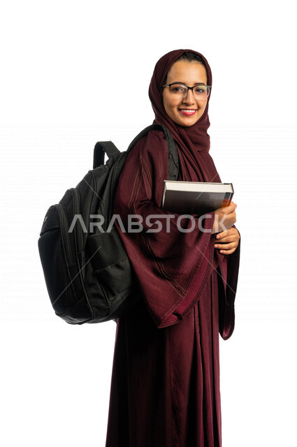 بورتريه طالبة جامعية عربية سعودية خليجية تحمل الكتب الجامعية , الاستعداد للعام الدراسي الجامعي الجديد, تلميذة مجتهدة متشوقة للذهاب الى الجامعه, مدارس وجامعات, التعليم في المملكة العربية السعودية , خلفية بيضاء .