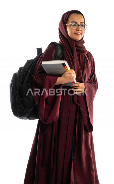بورتريه طالبة جامعية عربية سعودية خليجية تحمل الكتب الجامعية , الاستعداد للعام الدراسي الجامعي الجديد, تلميذة مجتهدة متشوقة للذهاب الى الجامعه, مدارس وجامعات, التعليم في المملكة العربية السعودية , خلفية بيضاء .