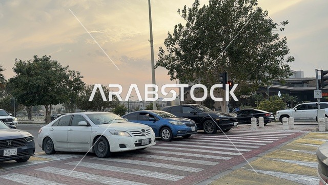عبور المشاة والسيارات فى ممشى همس فى المنطقة الشرقية ليلاً، المملكة العربية السعودية ،أجواء عائلية هادئة ، تجربة تنزه عصرية،وجهة ترفيهية مفتوحة،  مساحات للمشي والاسترخاء ،  جلسات ومقاعد خارجية