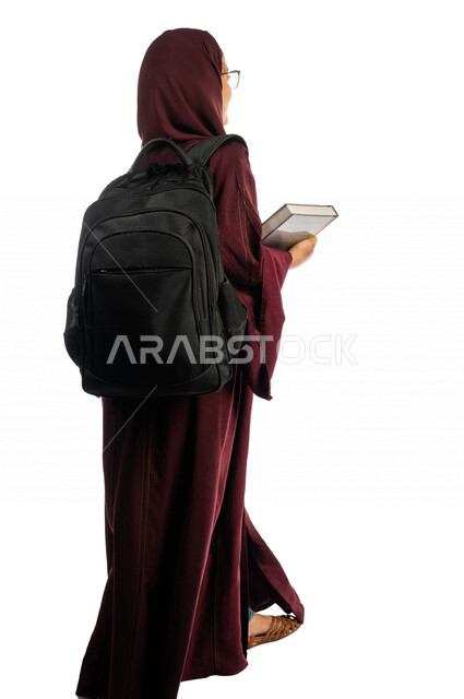 بورتريه طالبة جامعية عربية سعودية خليجية تحمل الكتب الجامعية , الاستعداد للعام الدراسي الجامعي الجديد, تلميذة مجتهدة متشوقة للذهاب الى الجامعه, مدارس وجامعات, التعليم في المملكة العربية السعودية , خلفية بيضاء .