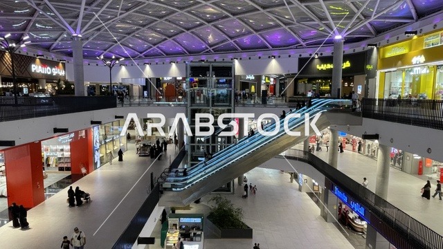 استخدام السلالم الكهربائية للتنقل بين الطوابق، مركز تسوق وترفيه في حي الأصالة شمال مدينة جدة في المملكة العربية السعودية سبتمبر 2025 ، تجربة تسوق ووجهة ترفيهية متكاملة للعائلات، خيارات التسوق تلبي مختلف الأذواق والاحتياجات، تصميم عصري وماركات عالمية ومحلية