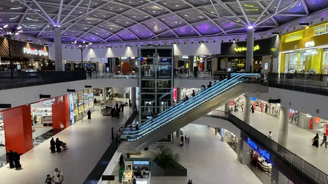 استخدام السلالم الكهربائية للتنقل بين الطوابق، مركز تسوق وترفيه في حي الأصالة شمال مدينة جدة في المملكة العربية السعودية سبتمبر 2025 ، تجربة تسوق ووجهة ترفيهية متكاملة للعائلات، خيارات التسوق تلبي مختلف الأذواق والاحتياجات، تصميم عصري وماركات عالمية ومحلية